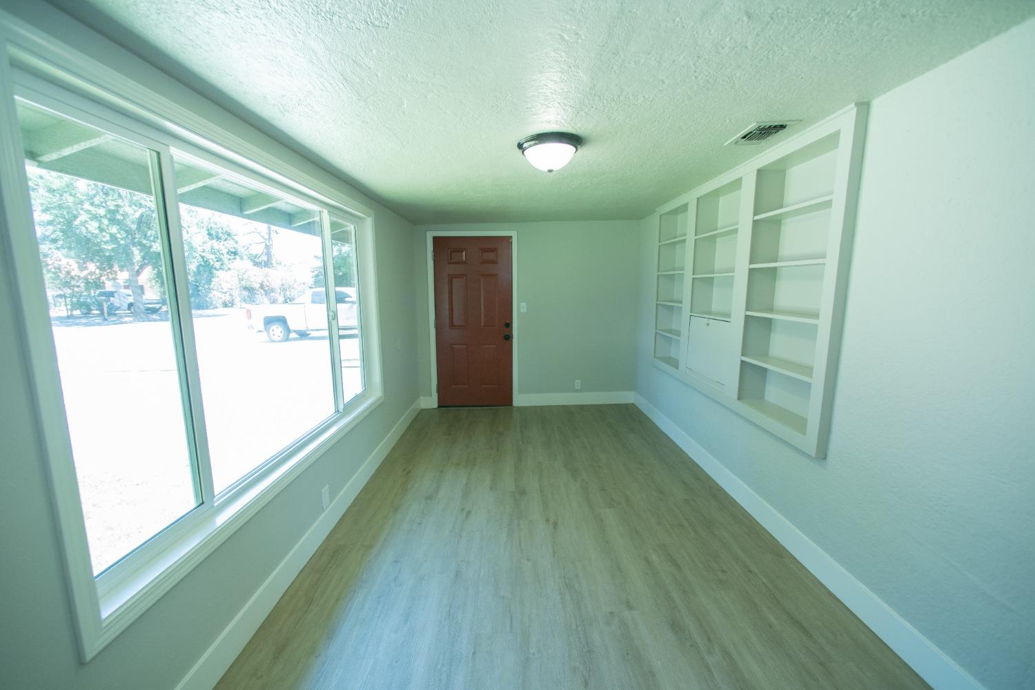 1136 East Griffith Way Fresno, CA 93704 - Photo 3 of 33 a view of a big room with wooden floor and windows