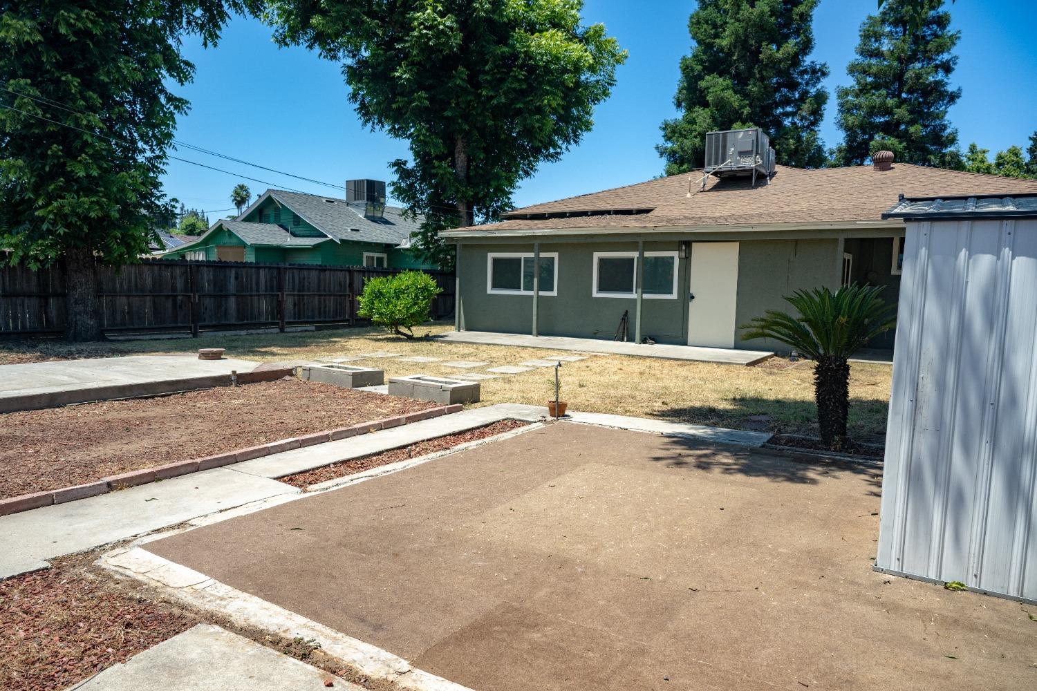 1136 East Griffith Way Fresno, CA 93704 - Photo 31 of 33 a front view of a house with a yard and garage
