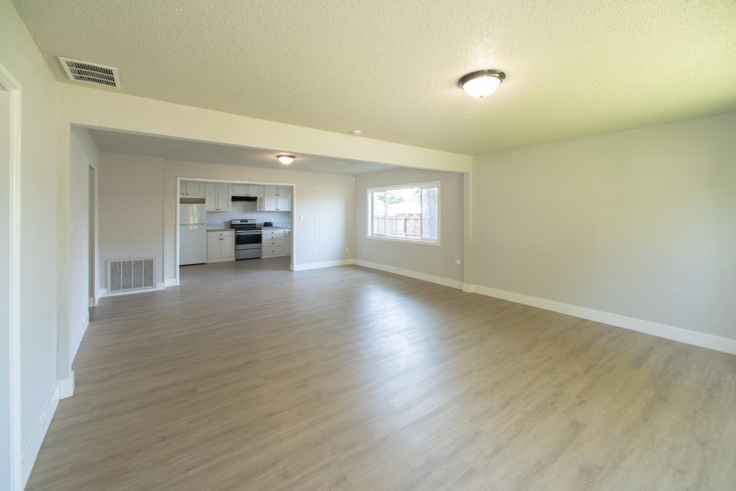1136 East Griffith Way Fresno, CA 93704 - Photo 6 of 33 wooden floor in an empty room with a window