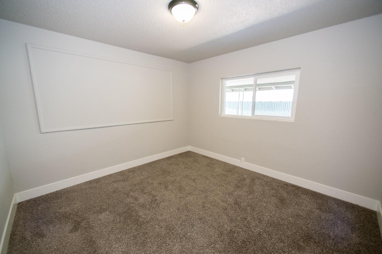 1136 East Griffith Way Fresno, CA 93704 - Photo 7 of 33 an empty room with a empty space and windows