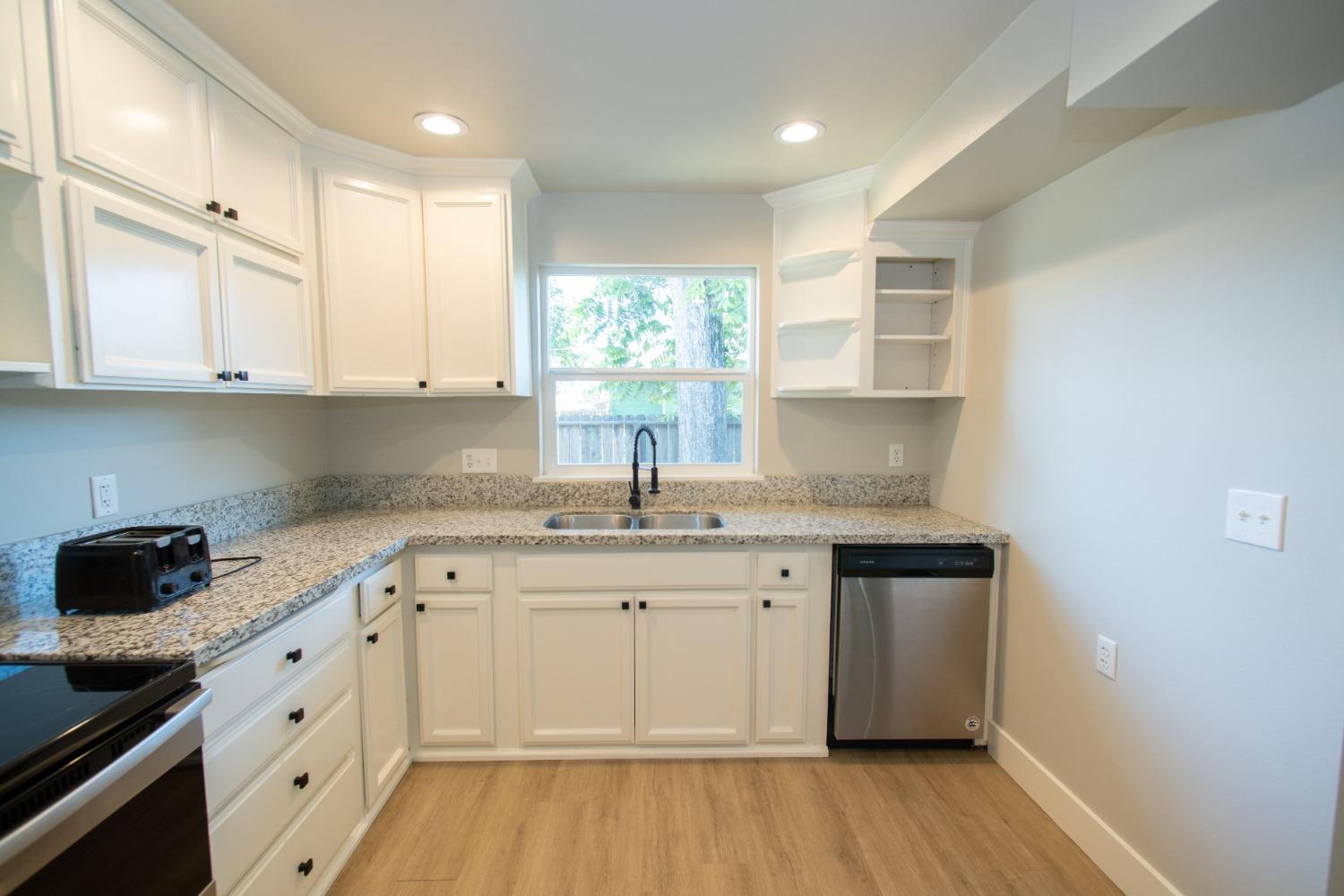 1136 East Griffith Way Fresno, CA 93704 - Photo 10 of 33 a kitchen with a sink stove and cabinets