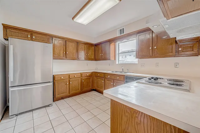 a view of kitchen island with stainless steel appliances granite countertop cabinets and outdoor view