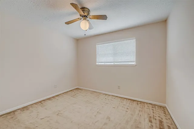 an empty room with closet and a chandelier fan
