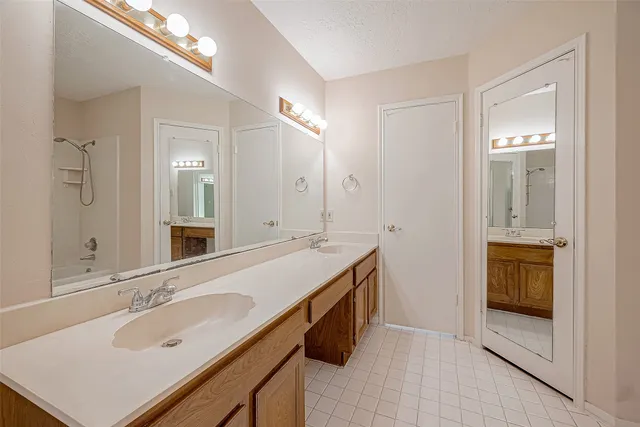 a spacious bathroom with a granite countertop sink and a mirror