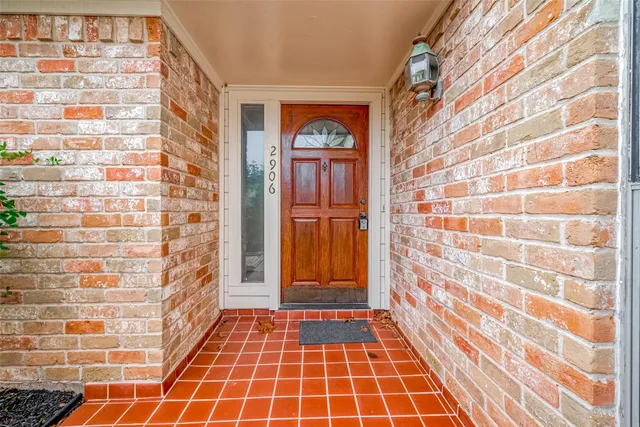 a view of a brick wall with wooden floor and a shower