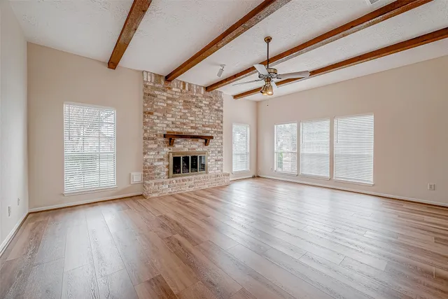 a view of empty room with wooden floor and window