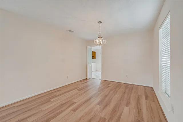 a view of a room with wooden floor fireplace and windows