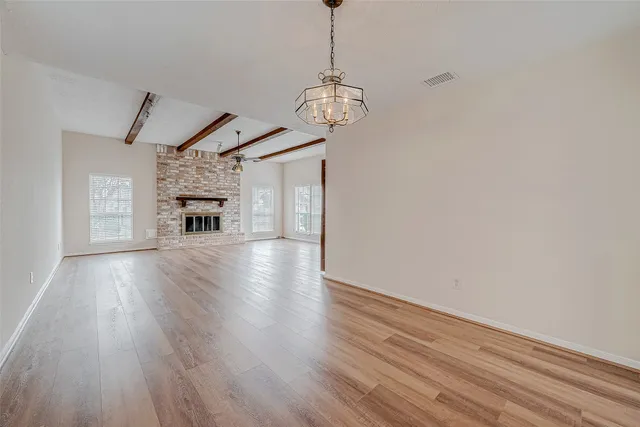 an empty room with windows and chandelier