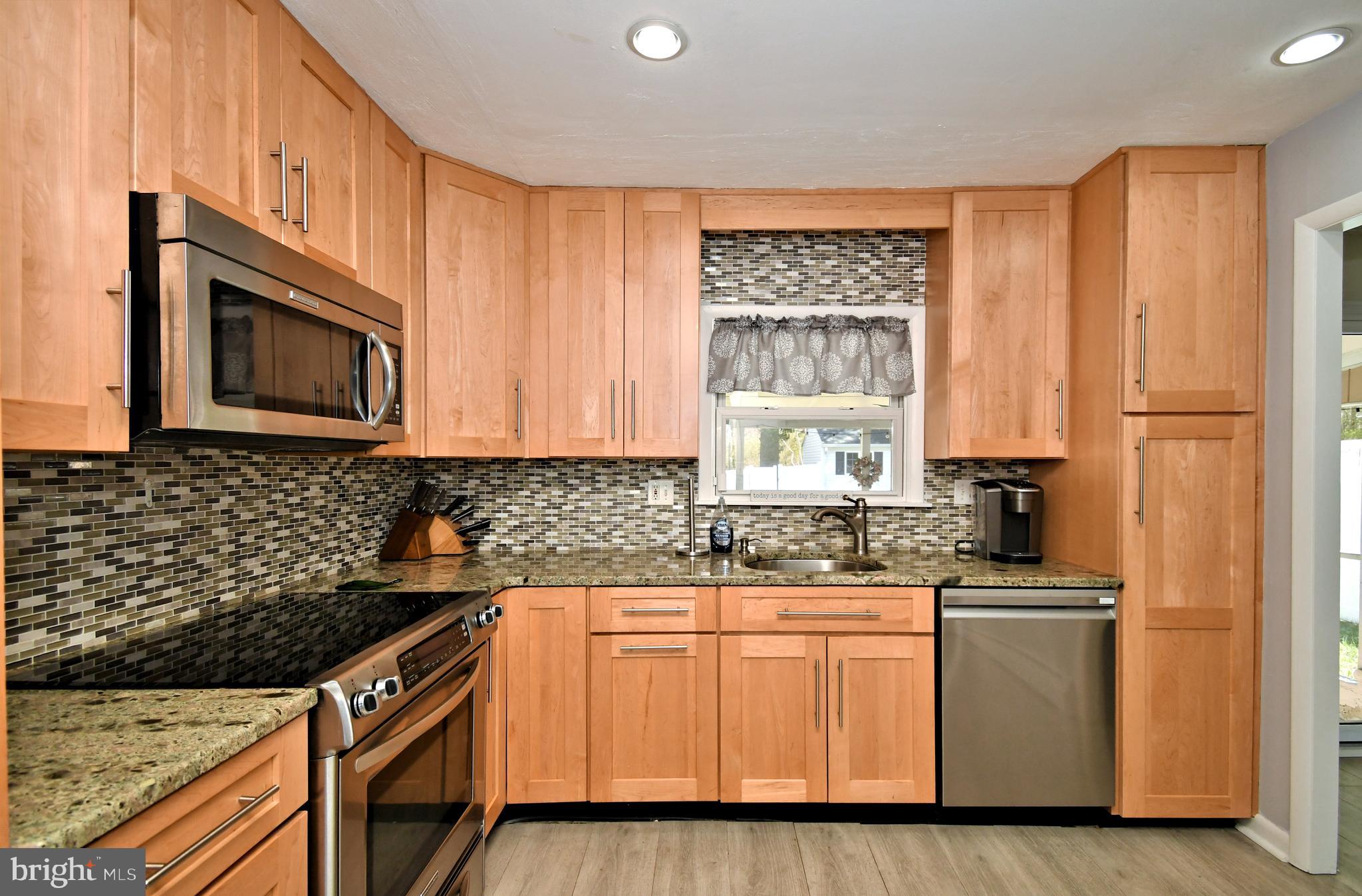 7 Sandy Drive Yardley, PA 19067 - Photo 14 of 42 a kitchen with stainless steel appliances granite countertop a stove a sink and a microwave