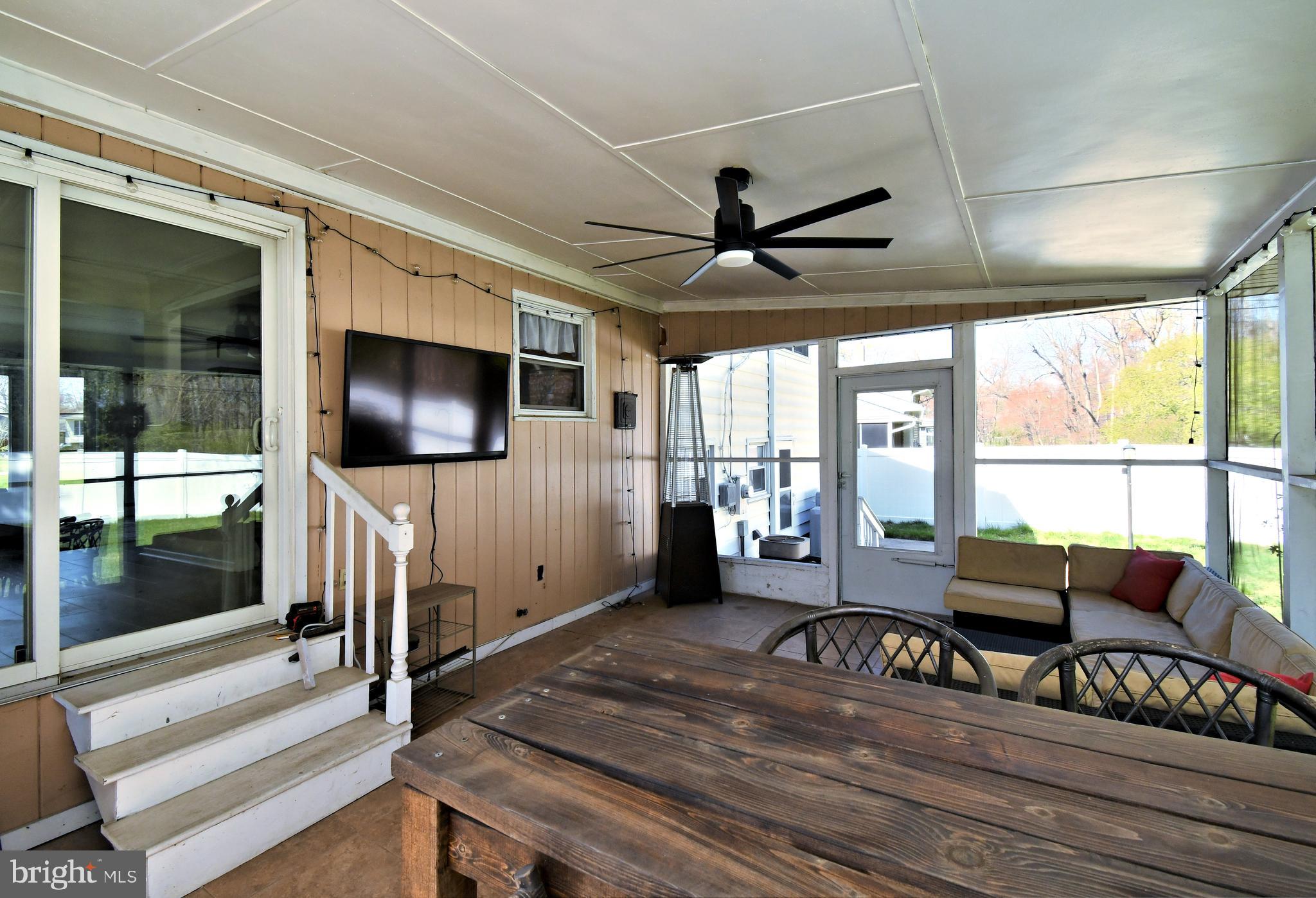 7 Sandy Drive Yardley, PA 19067 - Photo 33 of 42 a living room with furniture a flat screen tv and a floor to ceiling window