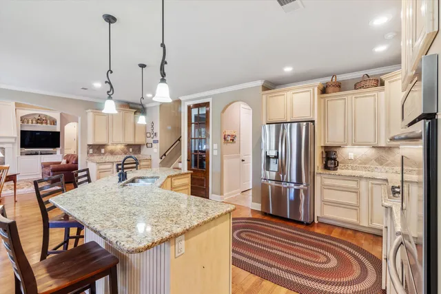 a kitchen with stainless steel appliances granite countertop a sink refrigerator and cabinets