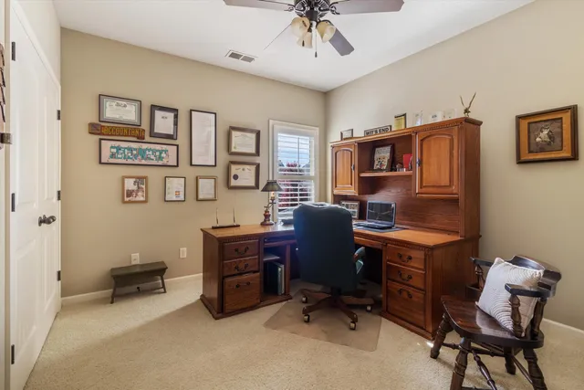 a bathroom with a granite countertop toilet a sink a mirror and a window