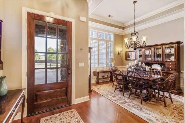 a view of a dining room and livingroom with furniture wooden floor a chandelier