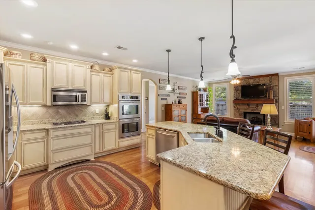 a kitchen with stainless steel appliances kitchen island granite countertop a sink and cabinets