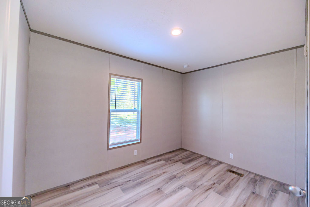 226 Mullis Street Dexter, GA 31019 - Photo 20 of 37 a view of empty room with wooden floor and fan