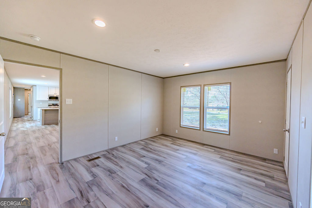 226 Mullis Street Dexter, GA 31019 - Photo 23 of 37 wooden floor in an empty room with a window