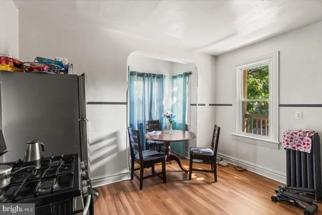 a kitchen with a refrigerator and wooden floor