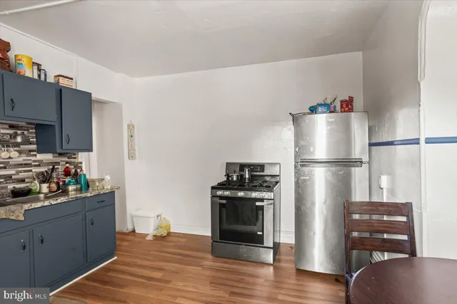 a kitchen with stainless steel appliances granite countertop a refrigerator and a stove top oven