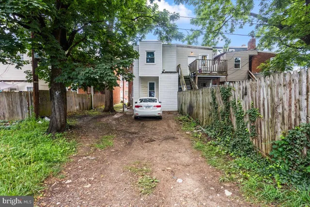 a white house that has tree in front of it