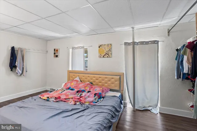 a bedroom with bed and wooden floor