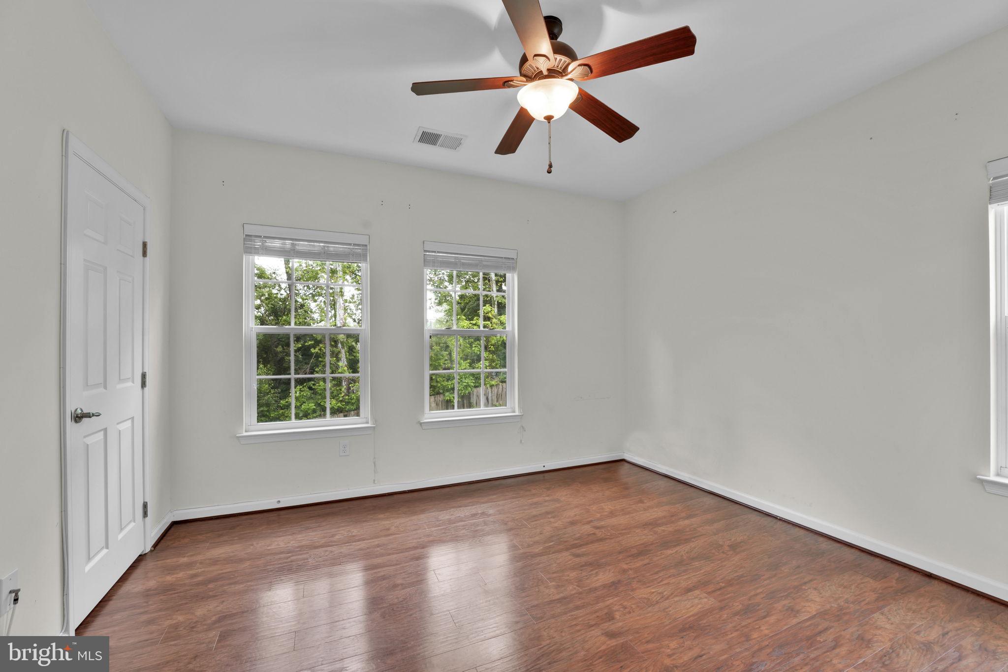 7138 Station House Road Elkridge, MD 21075 - Photo 13 of 42 an empty room with wooden floor fan and windows