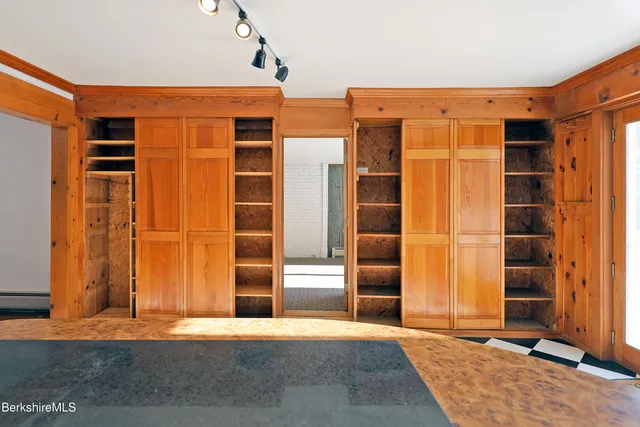 a view of an empty room with wooden floor and stairs