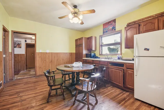a kitchen with a table chairs refrigerator and cabinets