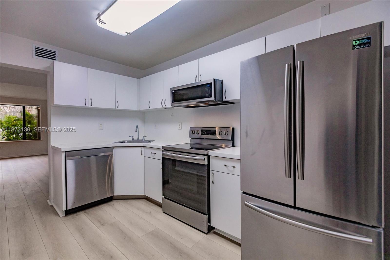 7820 Southwest 102nd Lane Miami, FL 33156 - Photo 9 of 31 a kitchen with stainless steel appliances a refrigerator sink and microwave