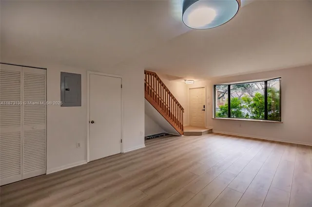 a view of a livingroom with wooden floor and window