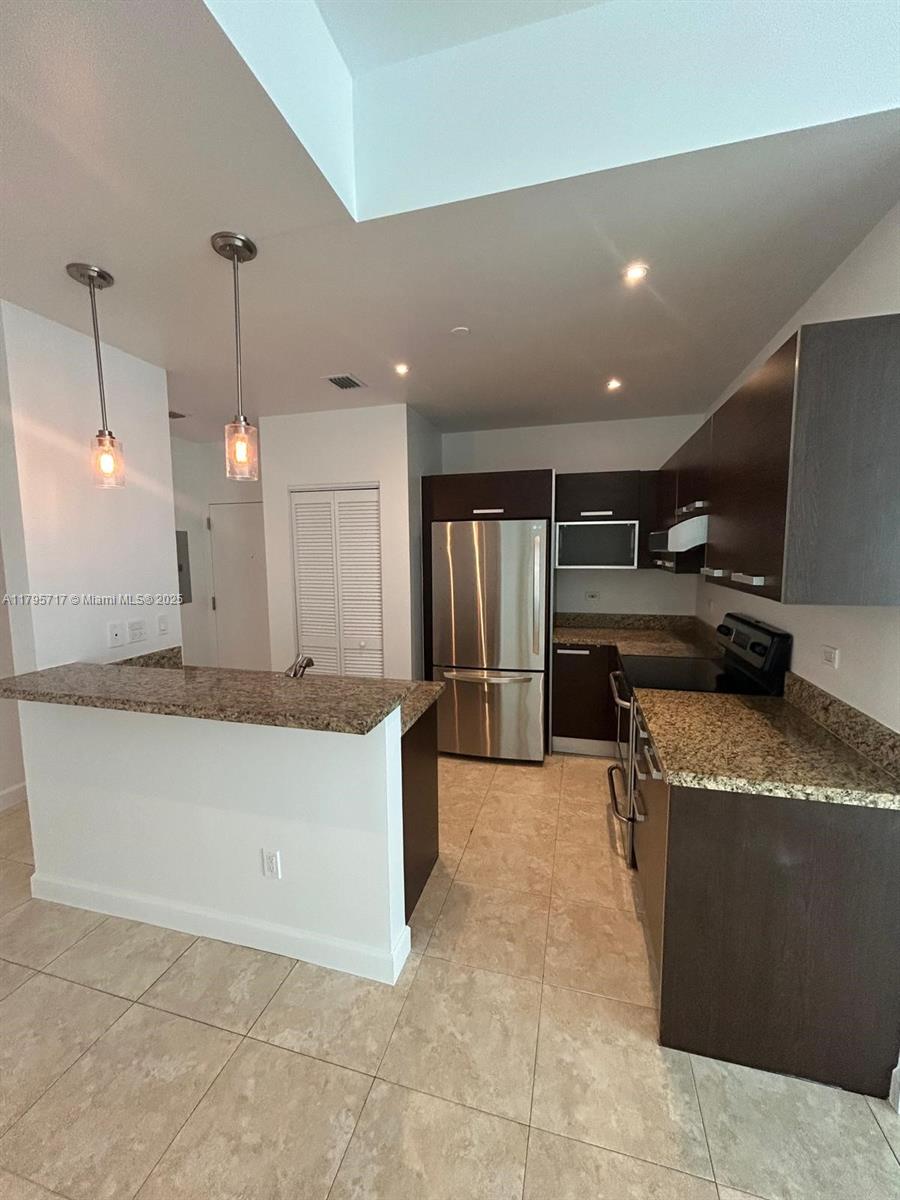 2525 Southwest 3rd Avenue, Unit 1402 Miami, FL 33129 - Photo 14 of 37 a large kitchen with a stove a refrigerator and a sink