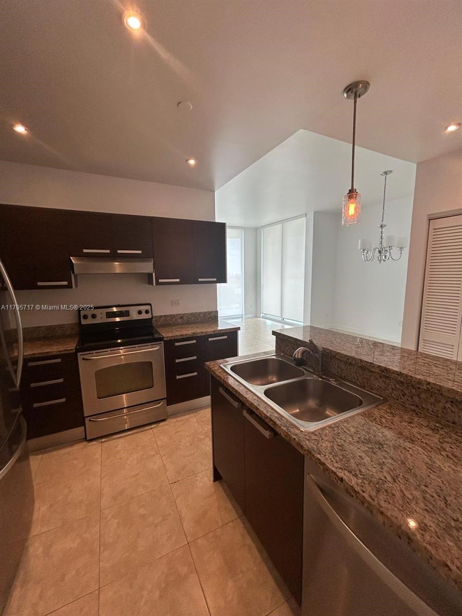 2525 Southwest 3rd Avenue, Unit 1402 Miami, FL 33129 - Photo 15 of 37 a kitchen with granite countertop a stove and a sink