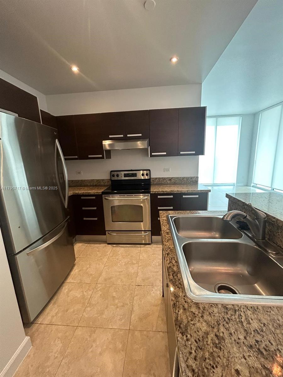 2525 Southwest 3rd Avenue, Unit 1402 Miami, FL 33129 - Photo 16 of 37 a kitchen with a sink a refrigerator and a stove top oven