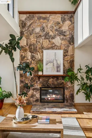 a living room with a fireplace and potted plant