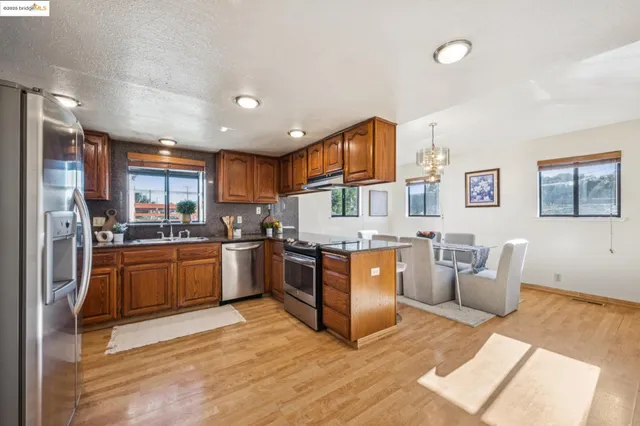 a kitchen with stainless steel appliances granite countertop a refrigerator stove top oven and sink