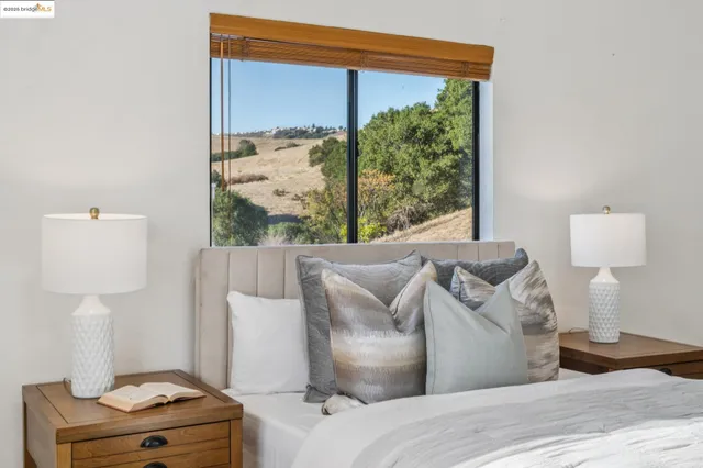 a bedroom with a bed wooden floor and a flat screen tv