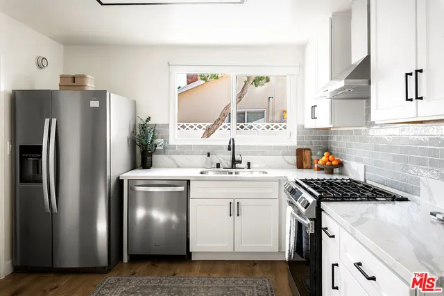 a kitchen with stainless steel appliances granite countertop a refrigerator and a sink