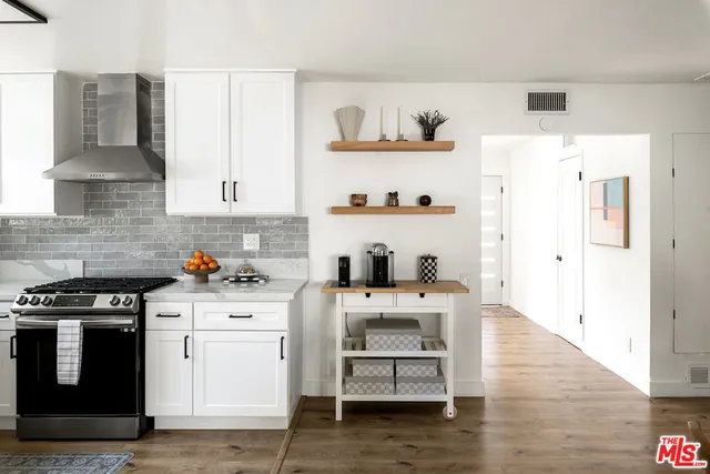 a kitchen with cabinets and wooden floor