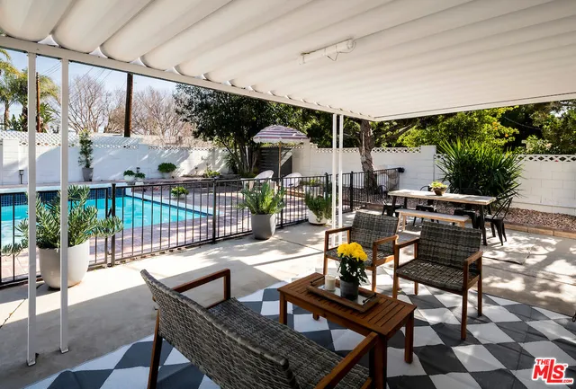a living room with patio furniture and a potted plant