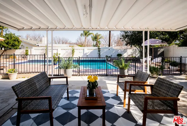 a view of a patio with a table chairs and a potted plant