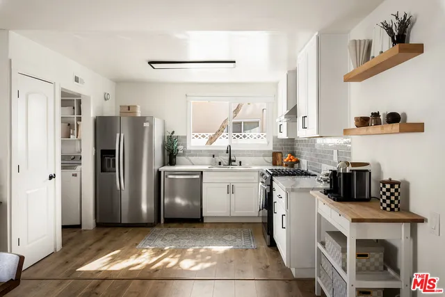 a kitchen with a sink a refrigerator and cabinets