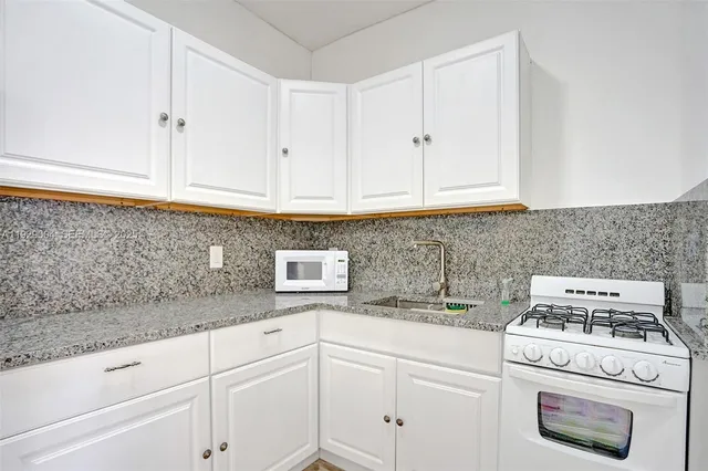 a kitchen with white cabinets and white appliances