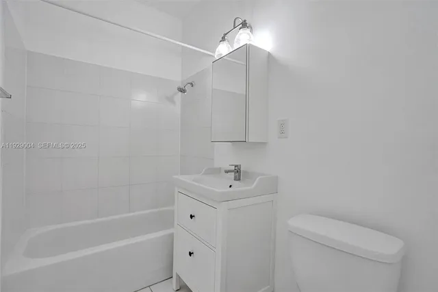 a view of a white house with a yard and potted plants