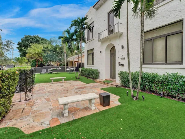 a front view of a house with a garden and plants