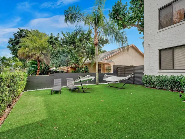 a view of a house with backyard and sitting area