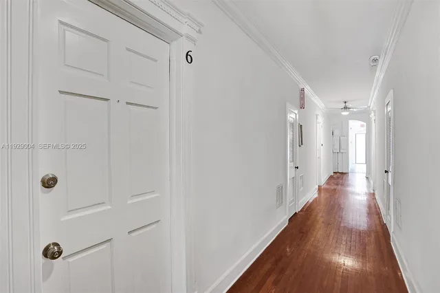 a view of a hallway with wooden floor and closet