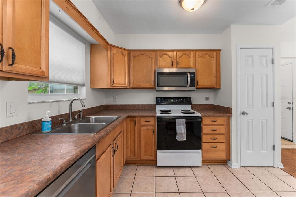 2026 Southwest 73rd Street Gainesville, FL 32607 - Photo 7 of 20 a kitchen with stainless steel appliances granite countertop a stove a sink and a microwave