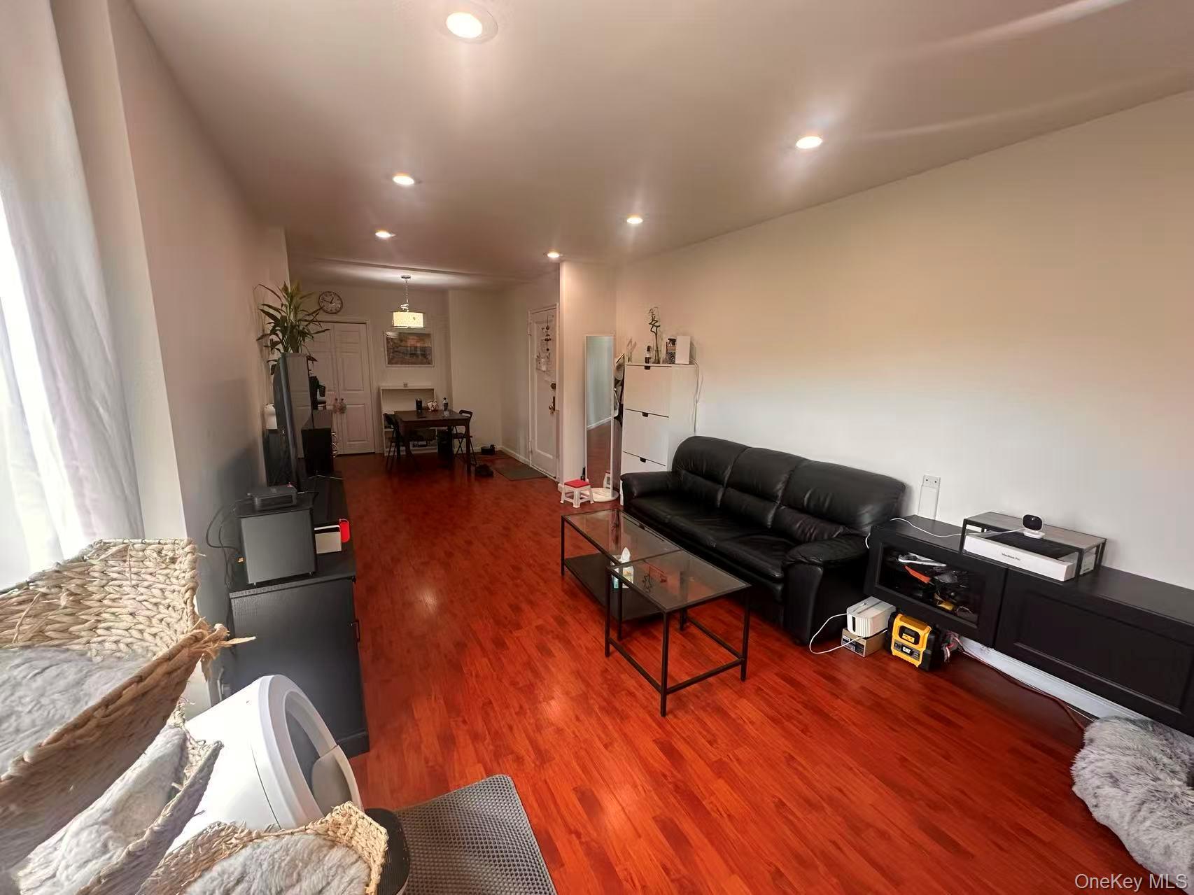 139-15 28th Road, Unit 6G Queens, NY 11354 - Photo 3 of 20 a living room with furniture and a wooden floor