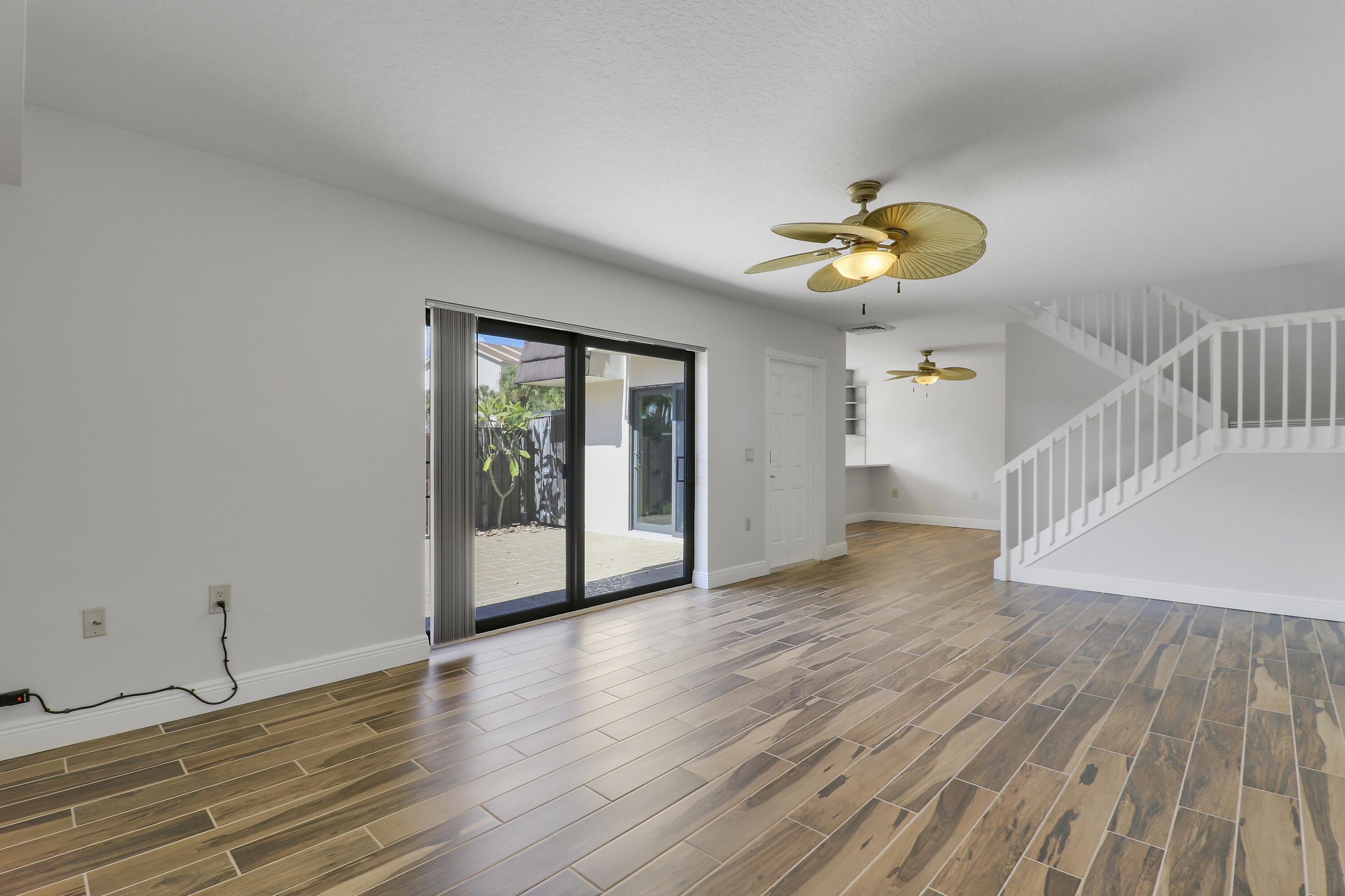 2324 23rd Court, Unit 55D Jupiter, FL 33477 - Photo 17 of 41 a view of an empty room with wooden floor and a window