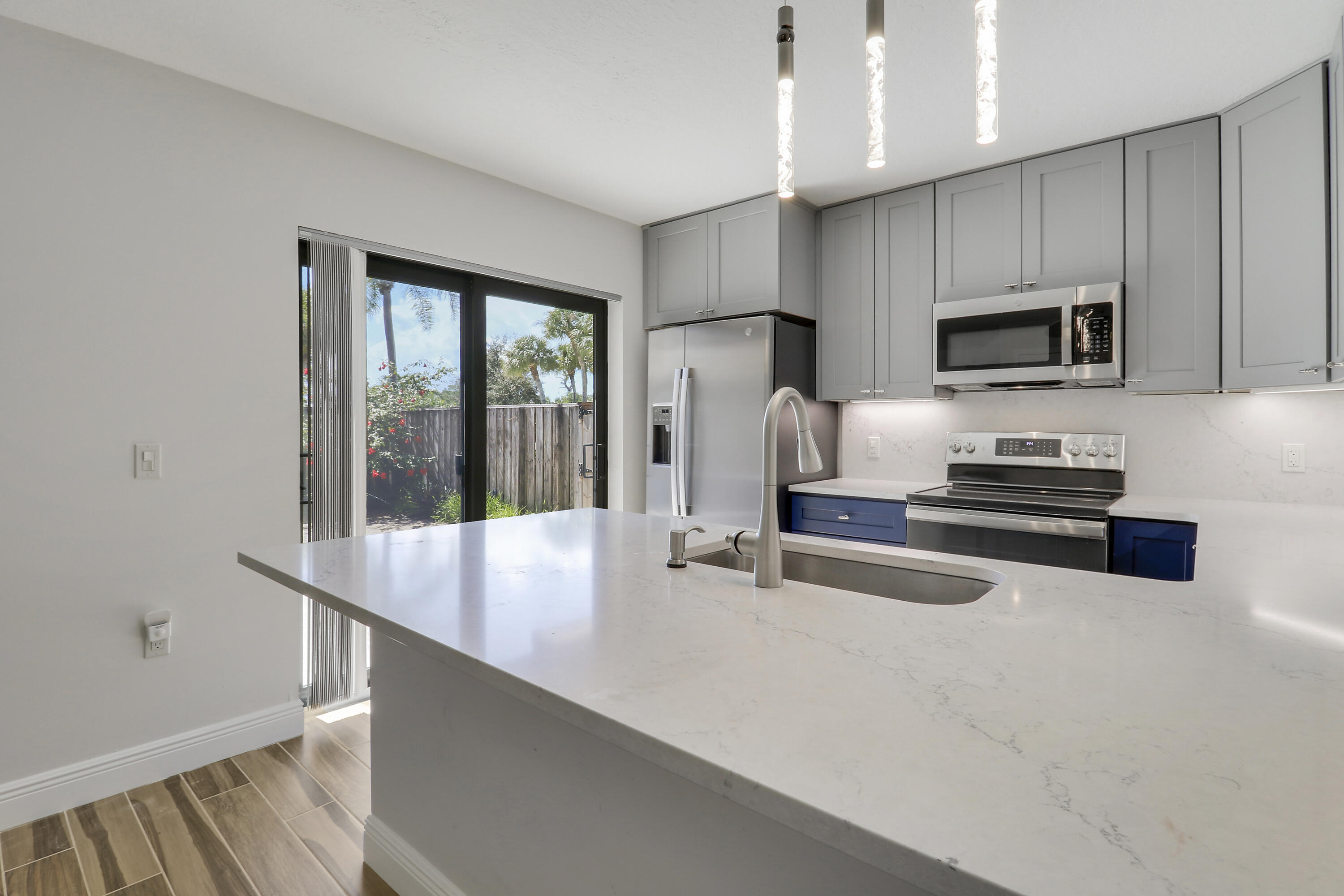 2324 23rd Court, Unit 55D Jupiter, FL 33477 - Photo 7 of 41 a kitchen with stainless steel appliances a stove a sink and a refrigerator