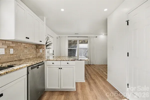 a kitchen with granite countertop white cabinets and white appliances